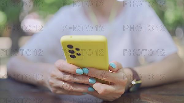 Close up of mature woman's hands use smartphone. Soft focus