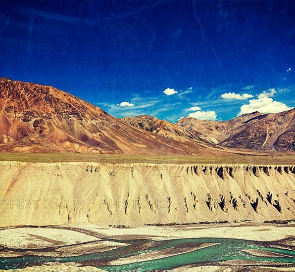 Vintage retro effect filtered hipster style travel image of Himalayan landscape in Hiamalayas near Baralacha La pass with grunge texture overlaid. Himachal Pradesh