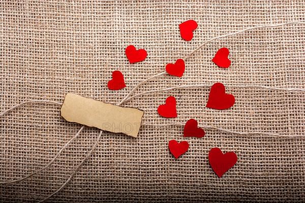 Love concept with heart shaped papers on linen threads