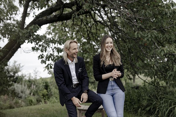 Man and woman talking on a wooden table in nature