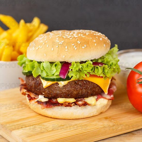 Hamburger cheeseburger fast food meal with fries on wooden board square in Stuttgart