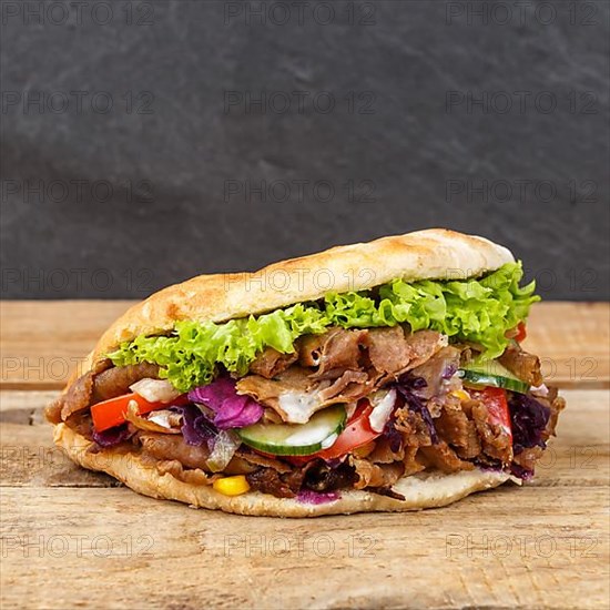 Doener Kebab Doner Kebap fast food meal in pita bread on wooden board square in Stuttgart