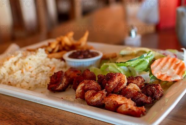 Breaded shrimp with rice and salad served on wooden table. Close up of breaded shrimp with french fries and salad served on wooden table. Seafood food concept served on the table