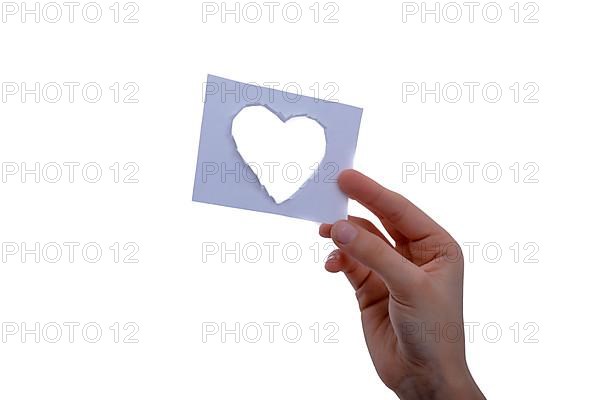 Hand holding a heart shape paper cut out of paper on a white background