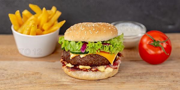 Hamburger Cheeseburger fast food meal menu with fries on wooden board Panorama in Stuttgart