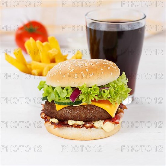 Hamburger Cheeseburger fast food meal menu with fries and cola drink on wooden board square in Stuttgart