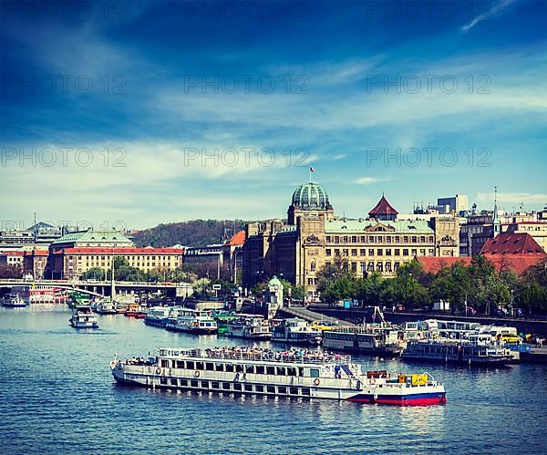 Vintage retro hipster style travel image of tourist boats on Vltava river in Prague