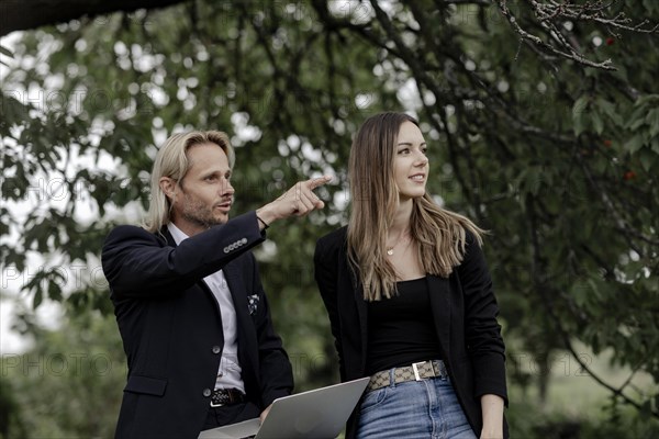 Man and woman talking on a wooden table in nature