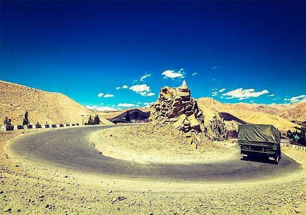 Vintage retro effect filtered hipster style travel image of Road in Himalayas with army truck. Ladakh