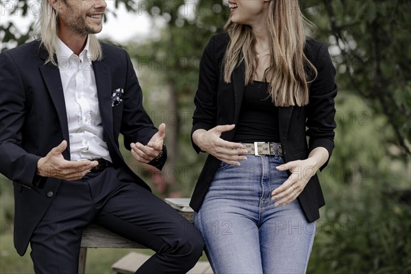 Man and woman talking on a wooden table in nature