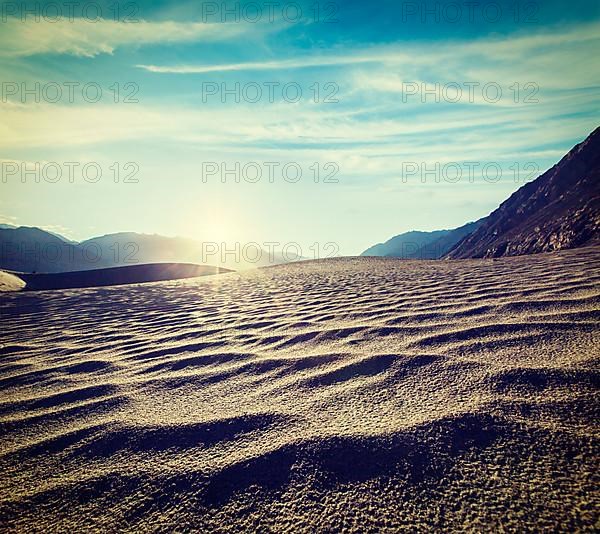 Vintage retro effect filtered hipster style travel image of Sand dunes in Himalayas on sunrise. Hunder