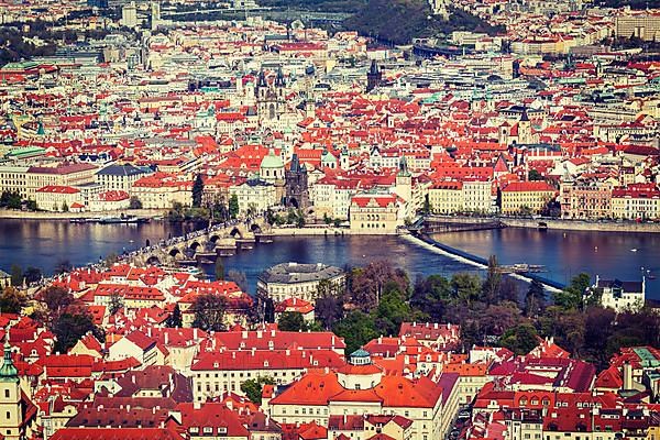 Vintage retro hipster style travel image of aerial view of Charles Bridge over Vltava river and Old city from Petrin hill Observation Tower. Prague