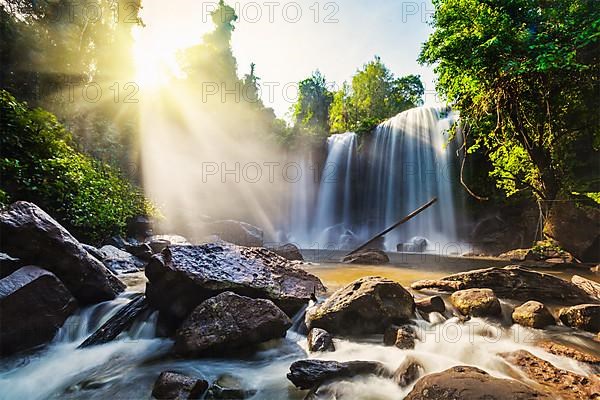 Tropical waterfall with sun rays in Cambodia