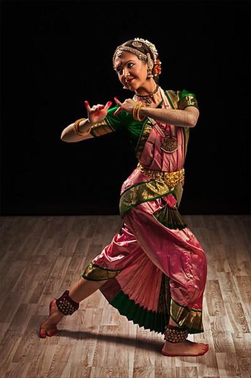 Young beautiful woman dancer exponent of Indian classical dance Bharatanatyam in Krishna pose