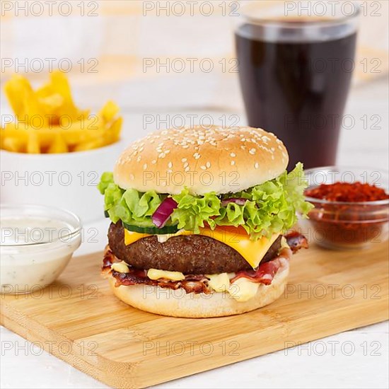 Hamburger Cheeseburger fast food meal menu with fries and coke drink on wooden board square in Stuttgart