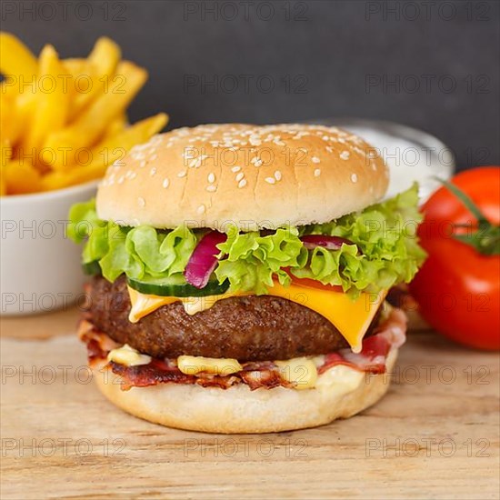 Hamburger Cheeseburger fast food meal menu with fries on wooden board square in Stuttgart