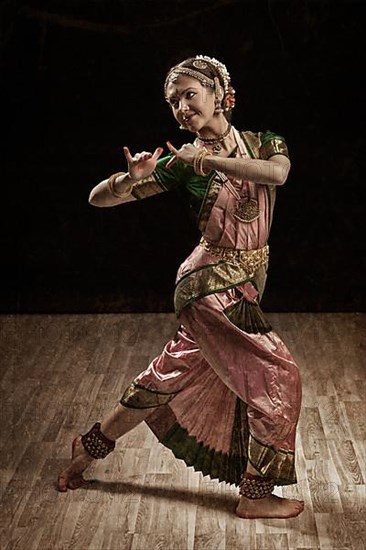 Vintage retro style image of young beautiful woman dancer exponent of Indian classical dance Bharatanatyam in Krishna pose