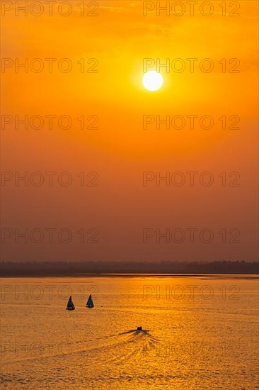 Yacht boats silhouettes in lake on sunset