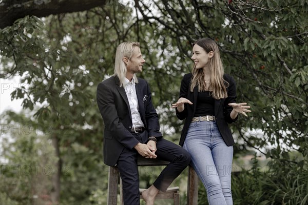 Man and woman talking on a wooden table in nature