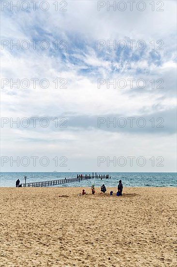 Strollers with children on the south beach in autumn