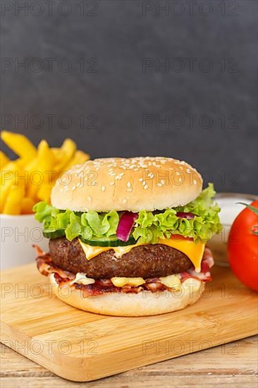 Hamburger cheeseburger fast food meal with fries on wooden board in Stuttgart