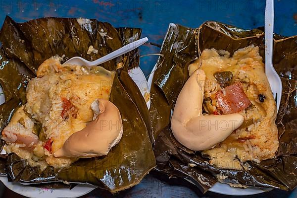 Two Nacatamales served in a banana leaf on the table. Top view of two traditional Nacatamales served on banana leaf