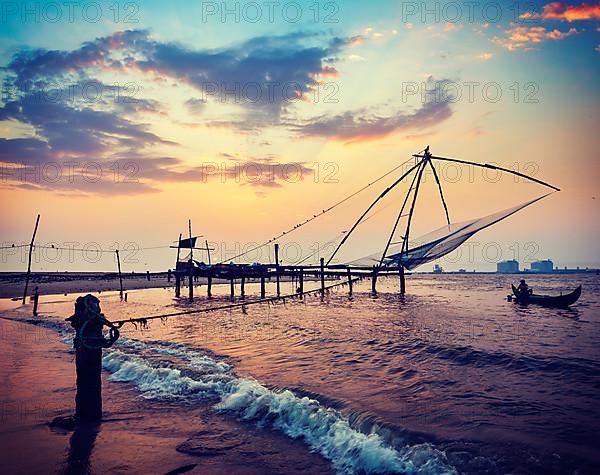 Vintage retro hipster style travel image of Kochi chinese fishnets on sunset. Fort Kochin