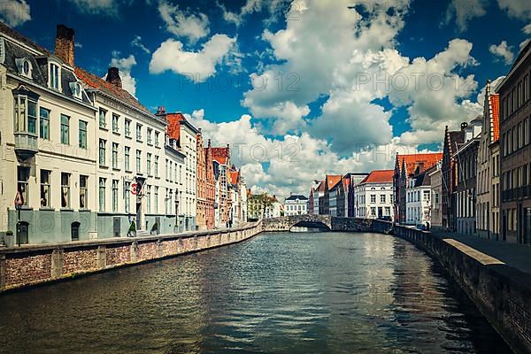 Vintage retro hipster style travel image of canal and old houses in Bruges