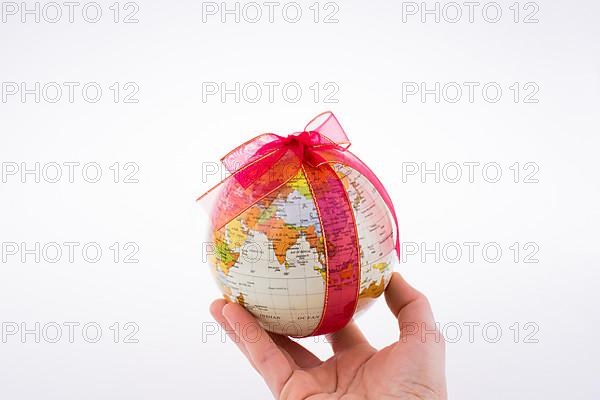 Globe tied with red ribbon on a white background