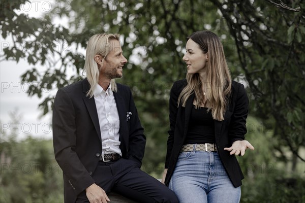 Man and woman talking on a wooden table in nature