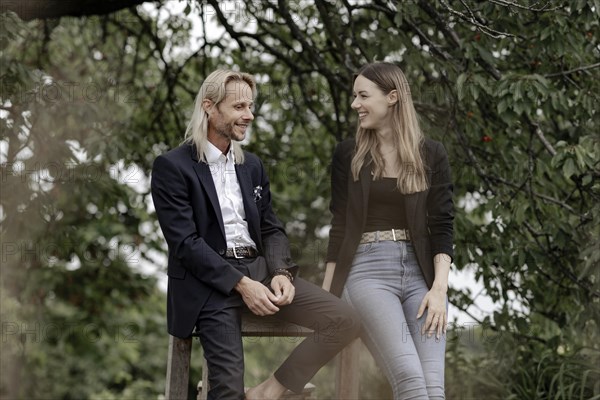 Man and woman talking on a wooden table in nature