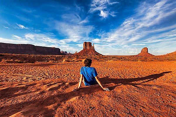 Tourist sitting in red sand