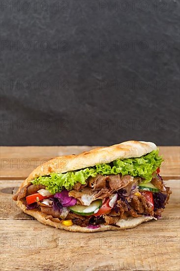 Doener Kebab Doner Kebap fast food meal in pita bread on wooden board in Stuttgart