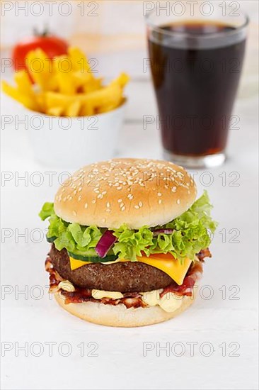 Hamburger cheeseburger fast food meal menu with fries and coke drink on wooden board in Stuttgart