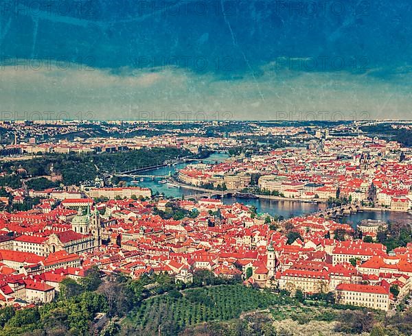 Vintage retro hipster style travel image of aerial view of Charles Bridge over Vltava river and Old city from Petrin hill Observation Tower with grunge texture overlaid. Prague