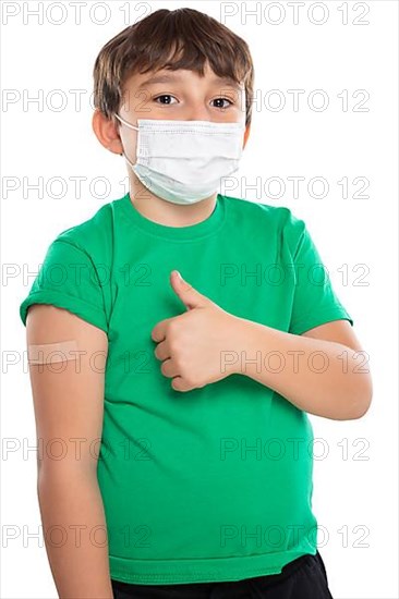 Child boy with plaster at children vaccination mask showing thumbs up against corona virus corona virus isolated exempt in Stuttgart