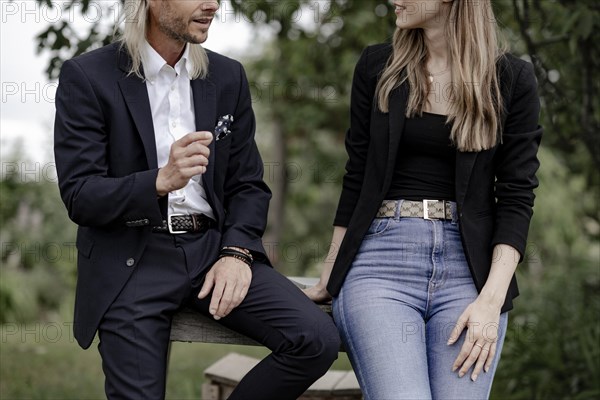 Man and woman talking on a wooden table in nature