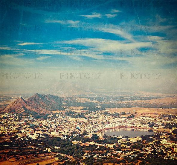 Vintage retro hipster style travel image of Holy city Pushkar aerial view from Savitri temple with grunge texture overlaid. Rajasthan