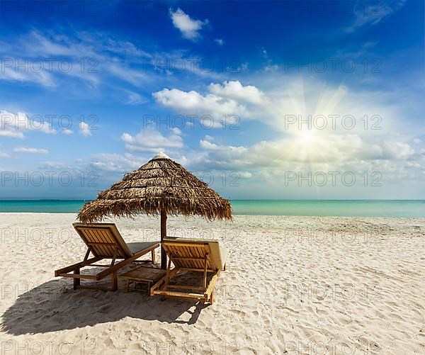 Two beach lounge chairs under tent on beach. Sihanoukville