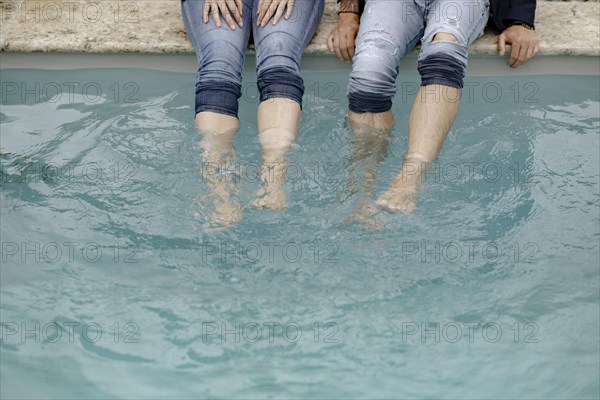 Four legs in jeans in the swimming pool