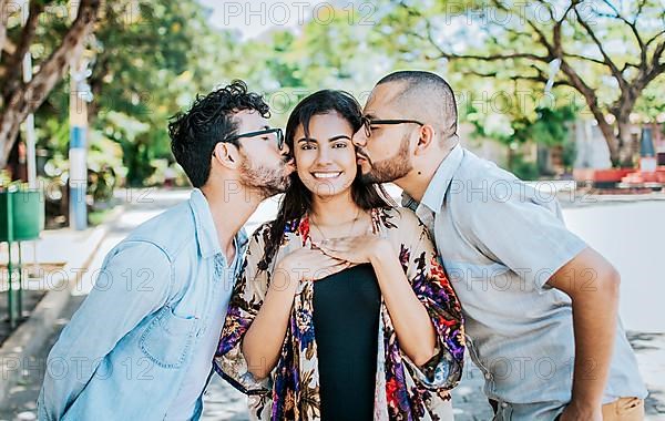 Two men kissing a girl cheek. Portrait of two guys kissing a girl cheek. Two young men kissing a woman cheek outdoor