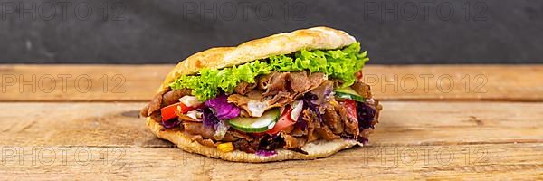 Doener Kebab Doner Kebap fast food in pita bread on wooden board Panorama in Stuttgart