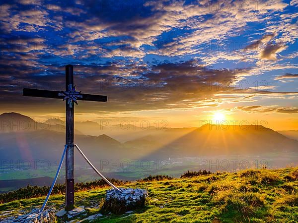 Summit cross of the Schlenken at sunset clouds