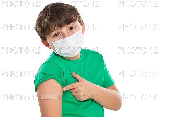 Child boy pointing finger at plaster during children vaccination mask against coronavirus corona virus isolated exempt in Stuttgart