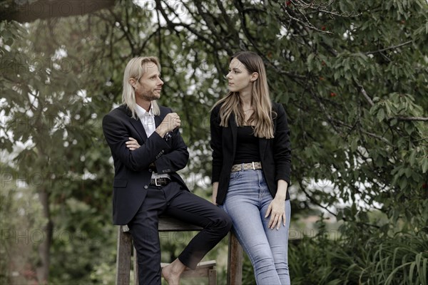 Man and woman talking on a wooden table in nature