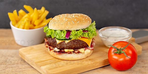 Hamburger cheeseburger fast food meal with fries on wooden board Panorama in Stuttgart