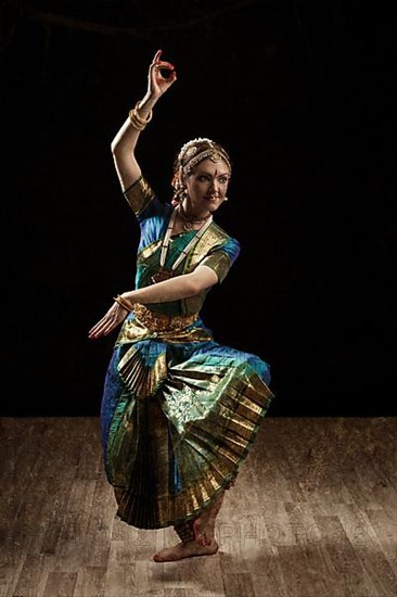 Vintage retro style image of young beautiful woman dancer exponent of Indian classical dance Bharatanatyam in Shiva pose