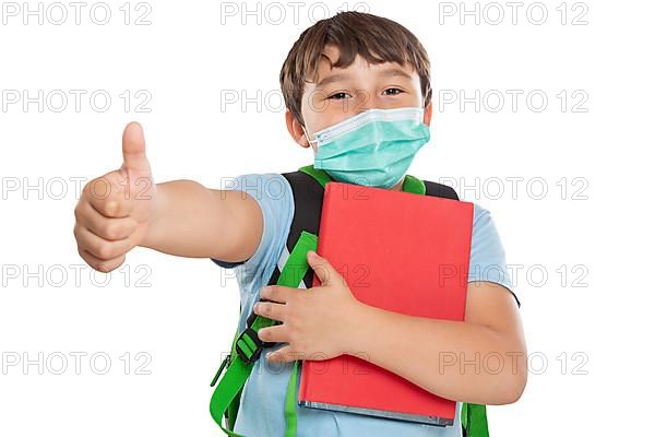 Young pupil child boy with mask against corona virus corona virus showing thumbs up isolated exempted in Stuttgart