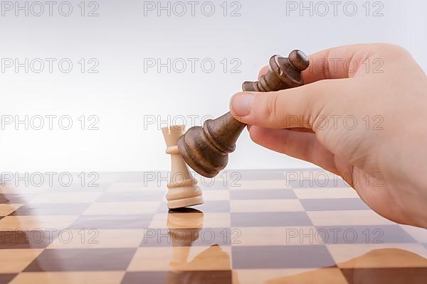 Person playing chess game making a move on board