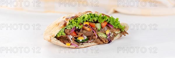 Doener Kebab Doner Kebap half fast food meal in pita bread on wooden board Panorama in Stuttgart